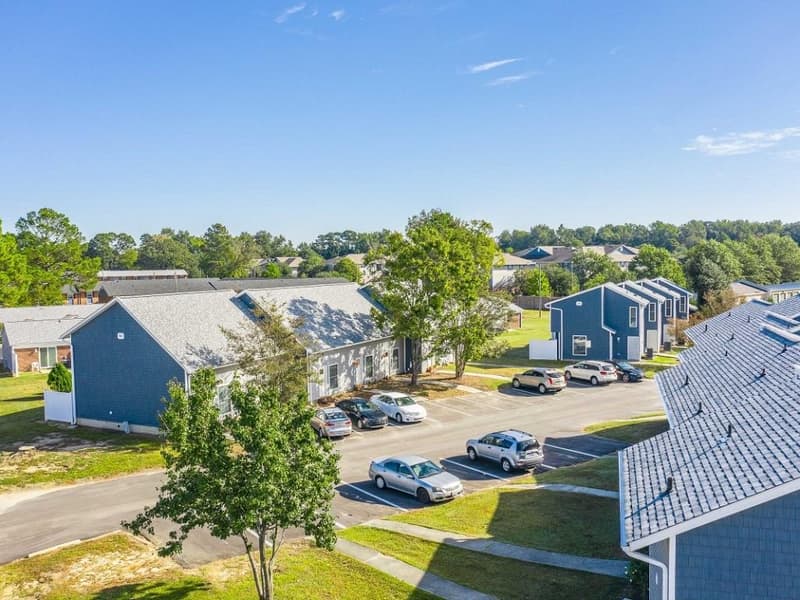 Two-bedroom buildings seen from above, with parking and lawns